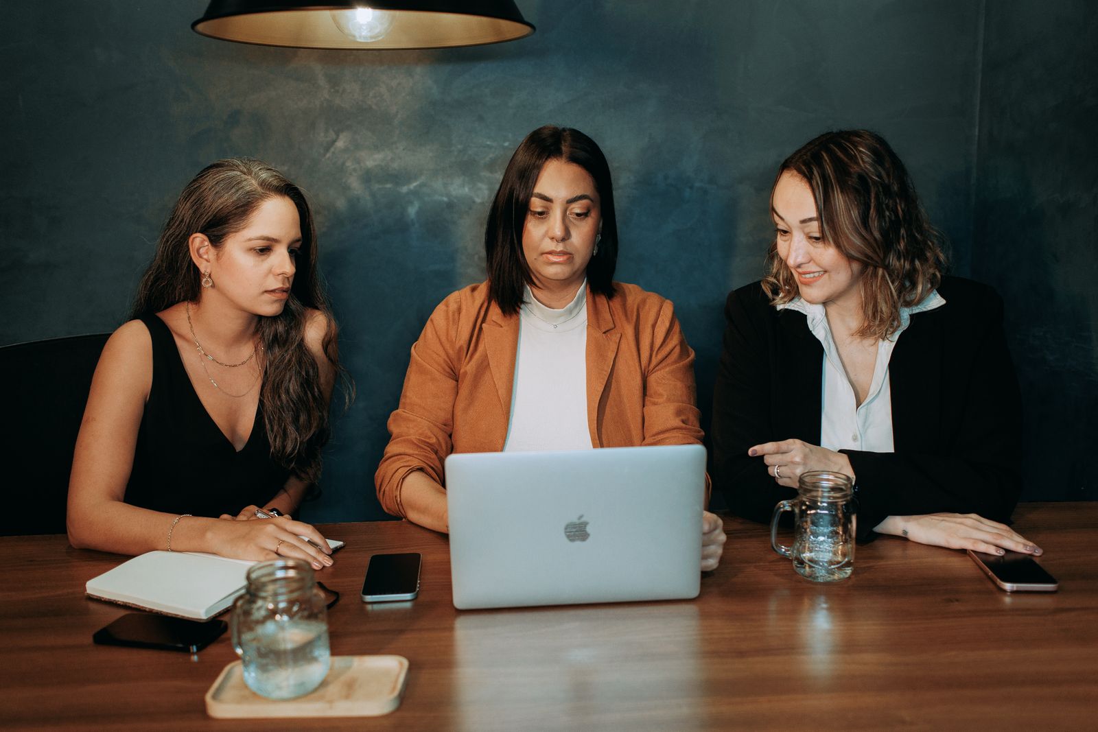 Tres mujeres colaborando frente a un computador en una sesión de trabajo